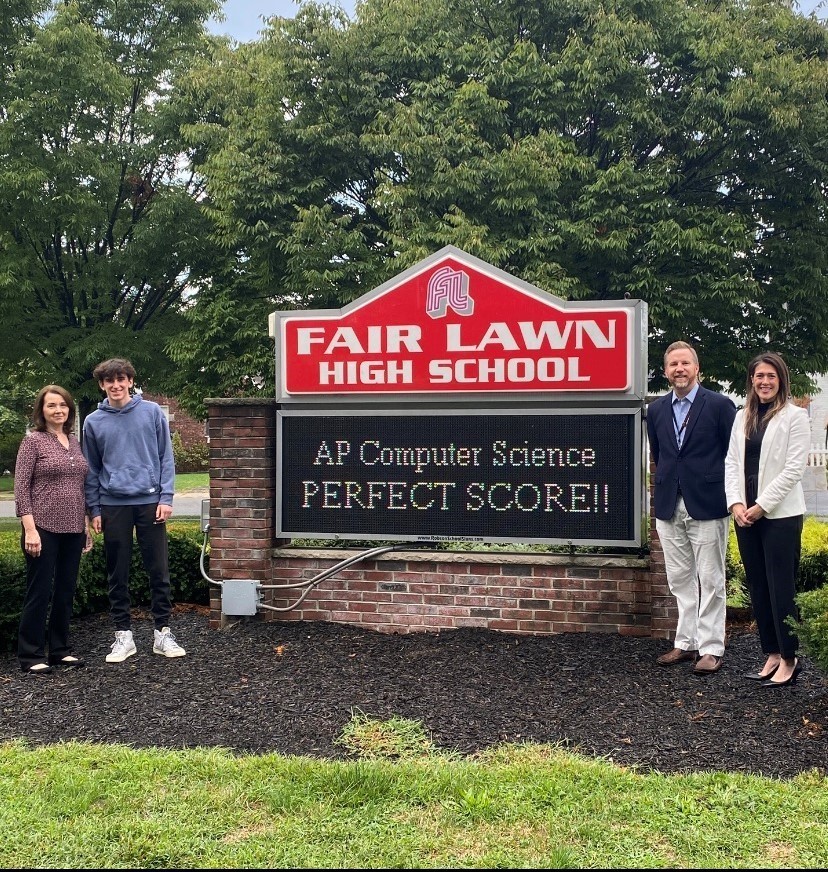 fair lawn high school sign with four people and trees