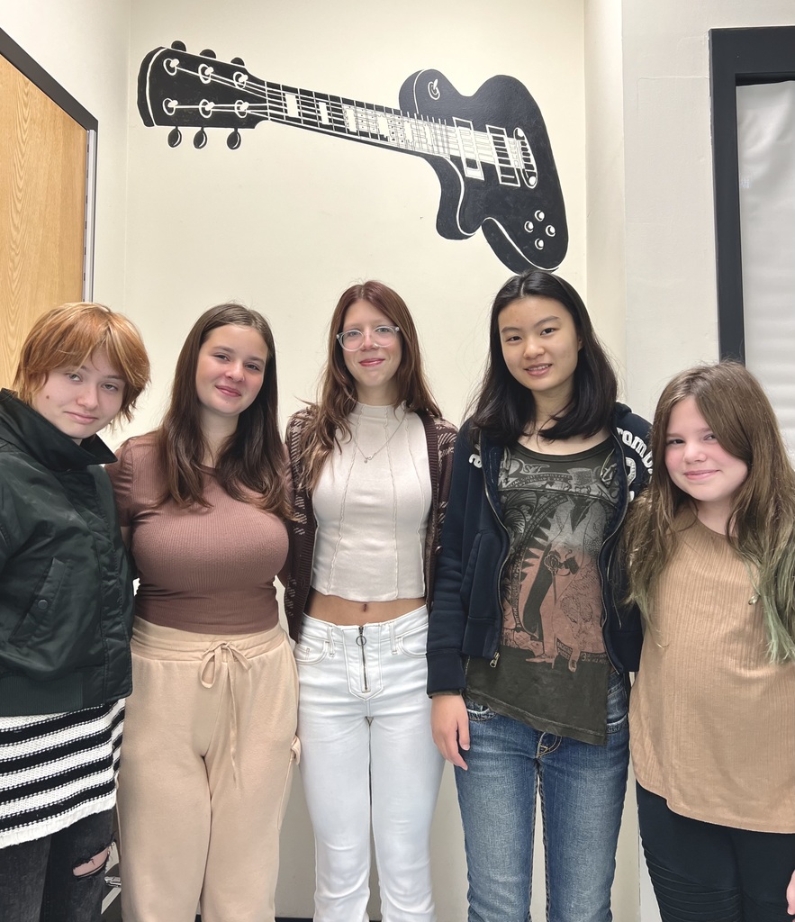 students wearing brown white blue and black with guitar 