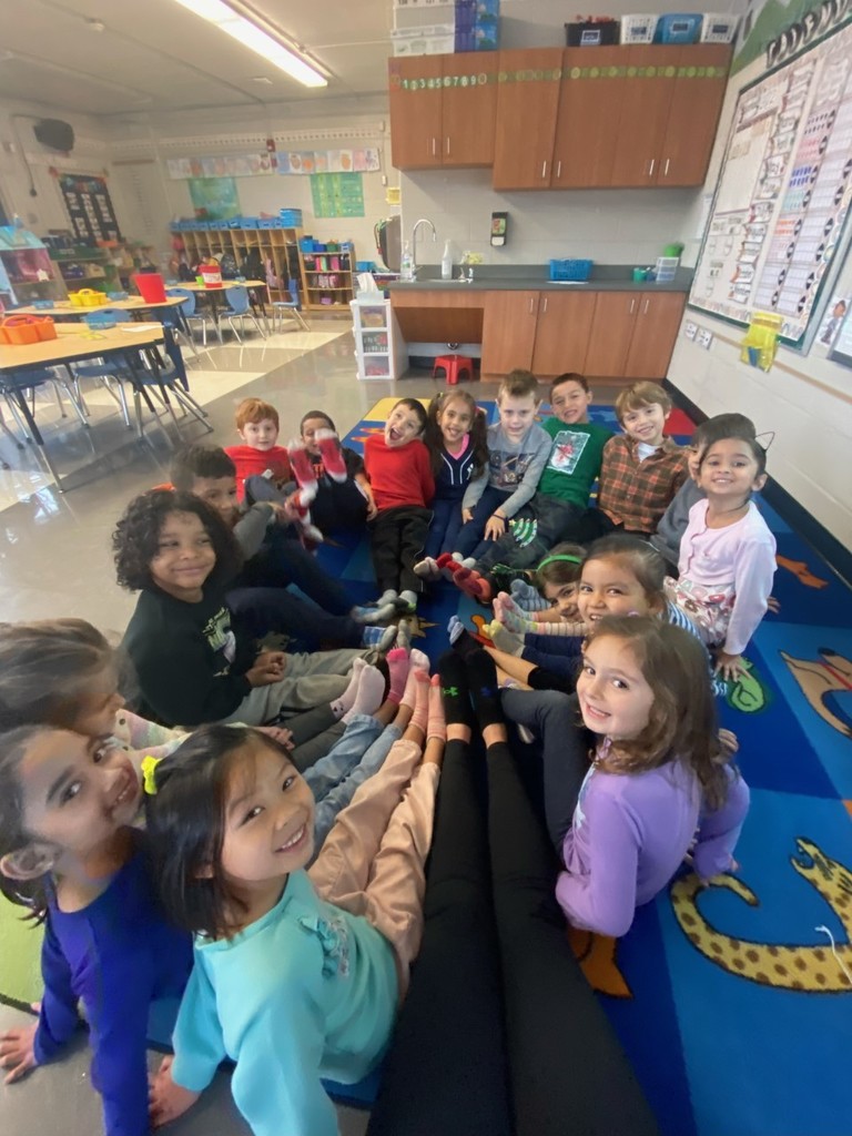 kindergarten students sitting on the classroom carpet without their shoes to celebrate St. Nicholas Day