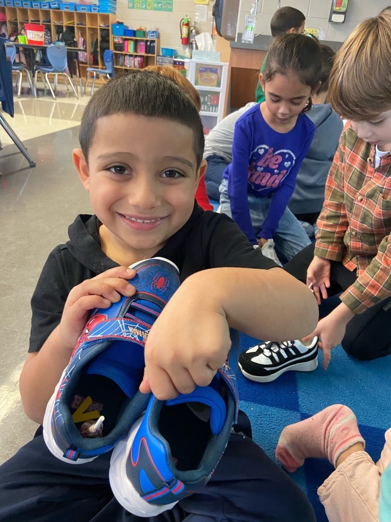 student showing his shoes filled with candy from St. Nicholas