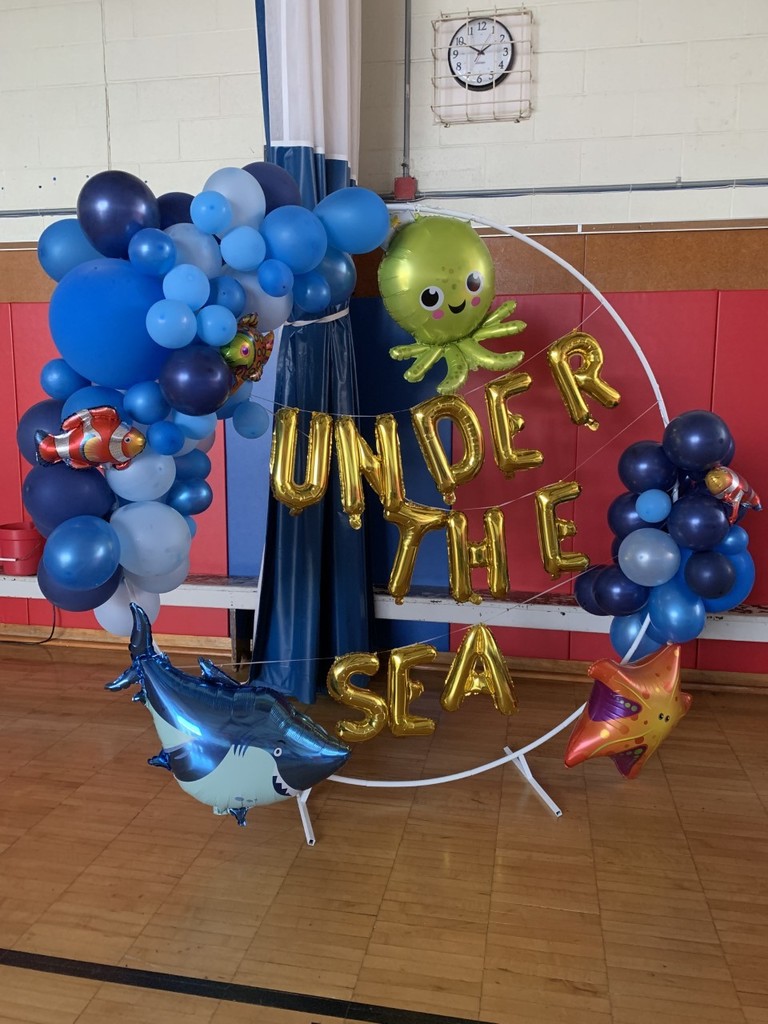 a blue and gold balloon arch that says under the sea with an octopus and starfish