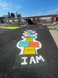 blacktop with multicolored affirmations painted on it