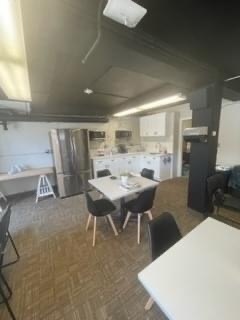 new staff lounge with fridge tables and chairs